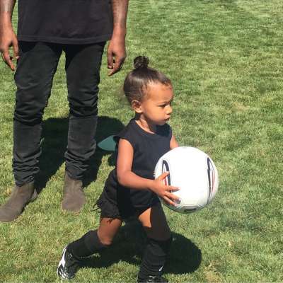 North West plays soccer in front of father Kanye West